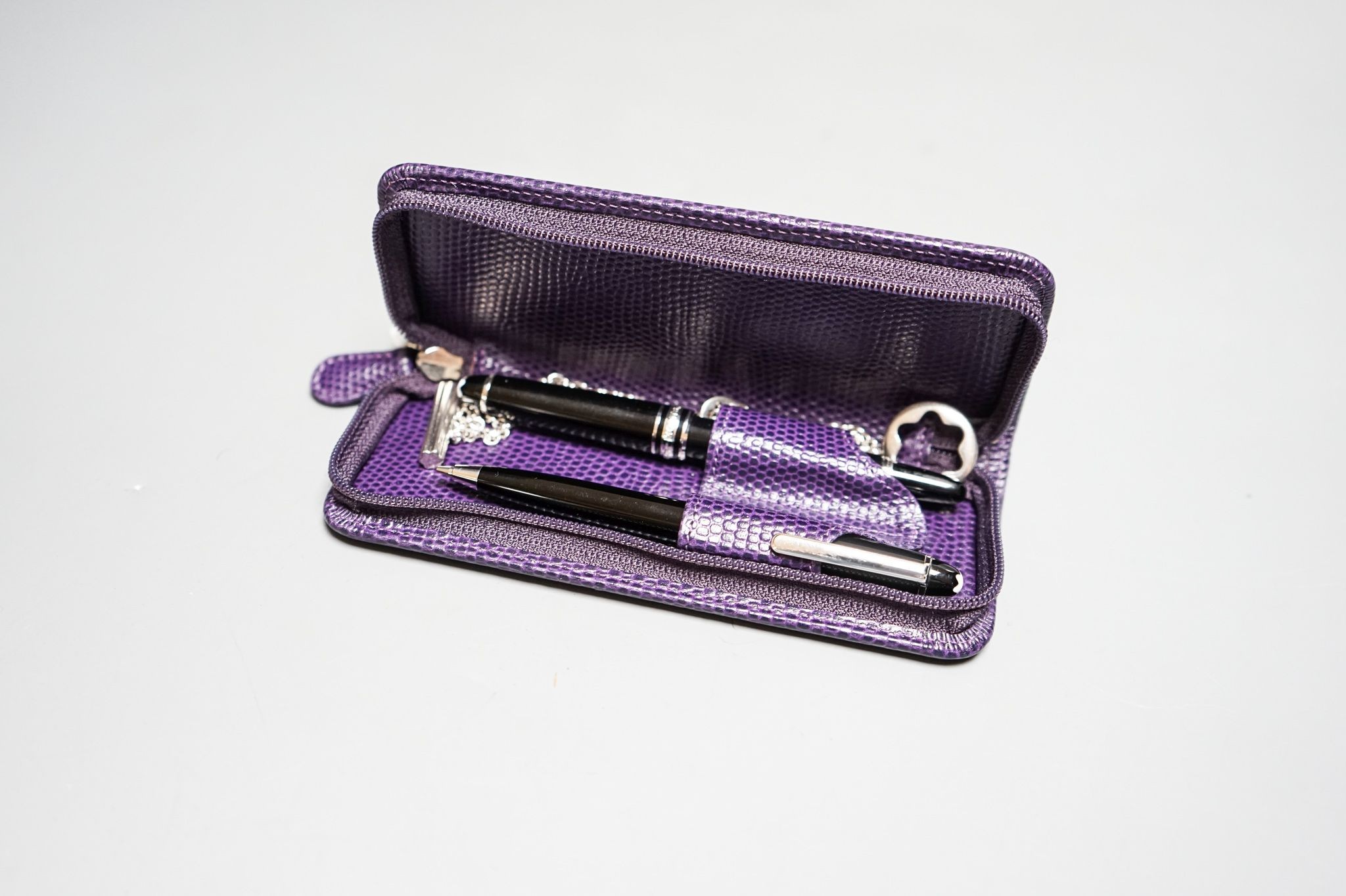 A Montblanc Meisterstuck small fountain, 11.2cm and ballpoint pen, and a chain in a purple case.